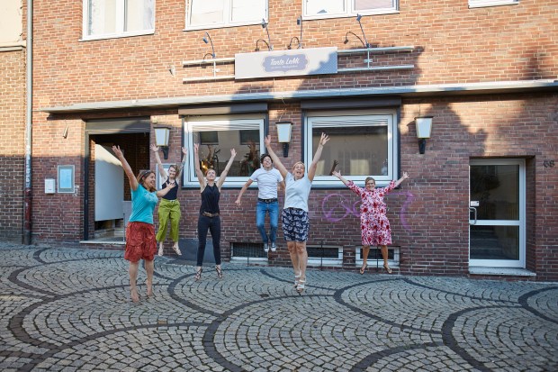 Teammitglieder springen vor der LeMi gleichzeitig in die Luft